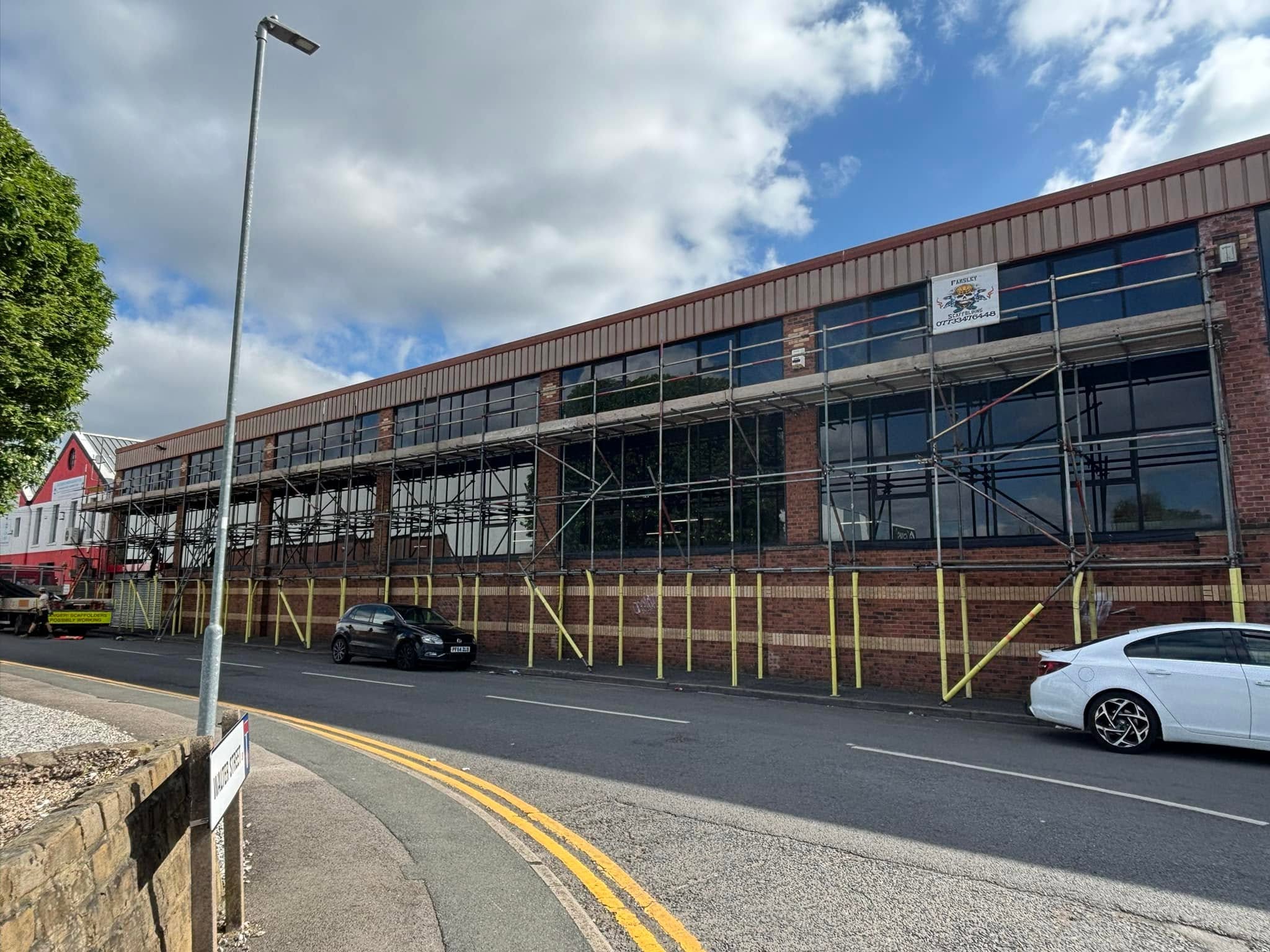 Large independent commercial scaffold covering the facade of a unit in Farsley