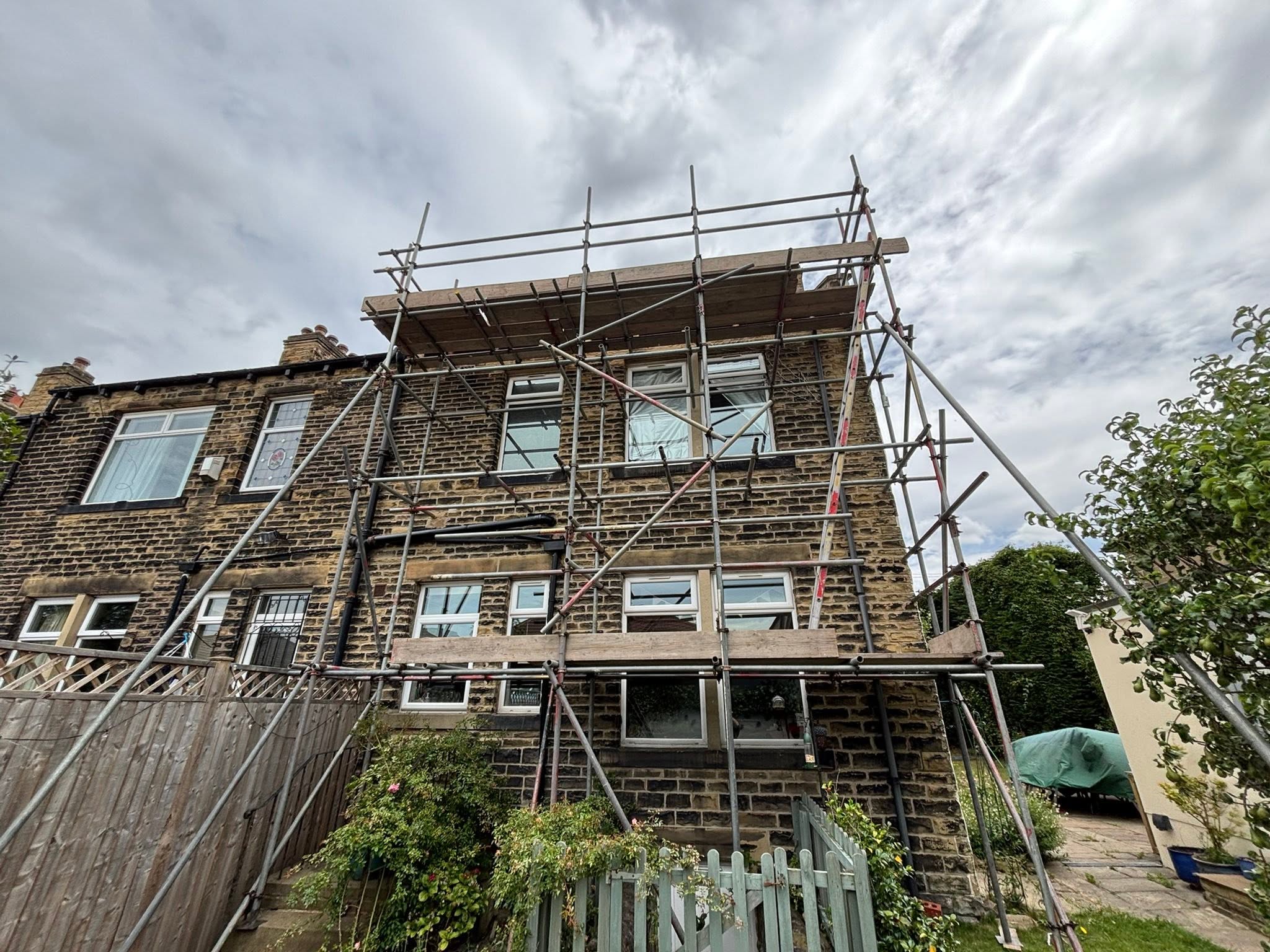 Tube and fitting scaffold around a terraced house in Leeds for roof and chimney work